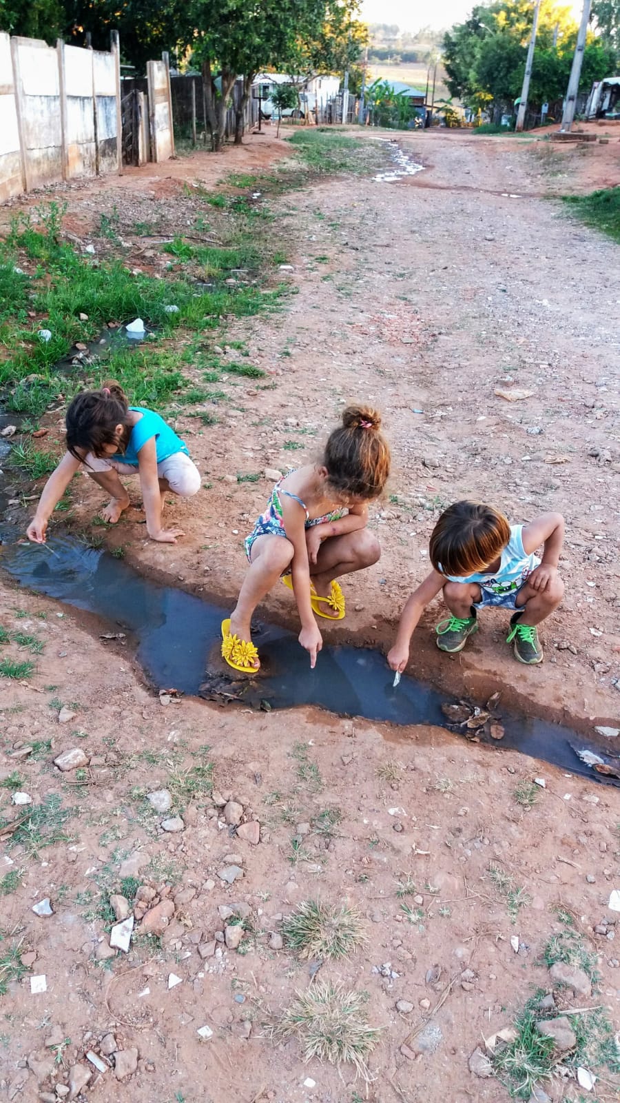 Crianças brincando em água de esgoto